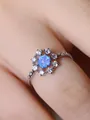 Macro detail of silver ring featuring round blue opal center and white cubic zirconia halo - Size 6 / Platinum Blue Opal