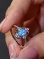 Detalle de anillo de plata con ópalo azul ovalado y halo floral de diamantes - US 6 / Ópalo Azul Platino