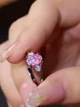 Vista macro di un anello con opale rosa ovale e diamanti laterali su fascia argento - Argento Viola