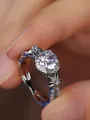 Macro-opname van ring met ronde diamant, bloemaccenten en luxe halo-zetting - Maat 5 / Witgoud Met Witte Zirkonia