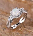 Silver ring featuring a large round opal center with floral side accents and split diamond band - Platinum White Opal