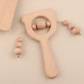 Detail of a bear-shaped beech wood baby rattle with smooth rotating beads and textures - Brown Bear