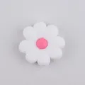 Detail view of a white silicone daisy bead with a pink center for DIY jewelry making - White Red