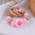 Beech wood and pink silicone flower teething bracelet for newborns on white fabric - Pink