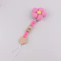 Rosa Stoffblumen-Schnullerkette mit Silikonperlen und Holzstern auf grauem Hintergrund - Fuchsia