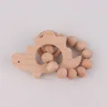 Natural beech wood teething ring with dinosaur shape and wooden beads for infants - Dinosaur