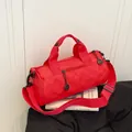 Vibrant red cylindrical sports duffel bag with reinforced handles and shoulder strap - Red