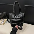 Sac bandoulière matelassé noir avec bandoulière réglable dans un bureau moderne - Noir