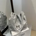 Silberne Schultertasche mit Plissee-Struktur und dekorativer Metall-Schmetterling - Silber