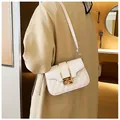 Elegante borsa a tracolla trapuntata bianca con chiusura dorata su una modella - Bianco