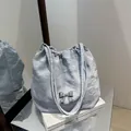 Light blue pleated shoulder bag with a silver metallic butterfly on a silver stand - Blue