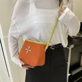 Sac seau orange avec bandoulière vert citron et détails métalliques en croix argent - Orange