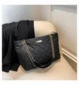 Bolso tote negro acolchado con textura geométrica en V y correas de cadena dorada - Negro