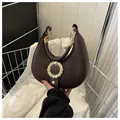 Dark brown leather crescent bag with golden buckle and textured lychee pattern finish - Brown