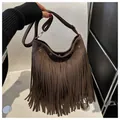Bohemian dark brown suede shoulder bag featuring long fringe and silver grommet hardware - Brown