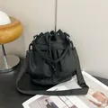 Bolso tipo cubo minimalista de nailon negro con correa ajustable y cordón de cierre - Negro