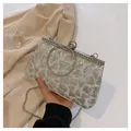Macro shot of silver sequin evening clutch with rhinestone handle and metal chain detail - White