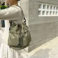Bolso tipo cubo minimalista de nailon verde militar con cordón, textura plisada y herrajes negros - Verde Militar