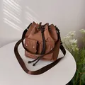 Minimalist dark brown drawstring bucket bag with front pockets and wide strap - Brown