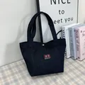 Dark blue denim tote bag with red embroidered patch 23 on a vintage plaid tablecloth - Black