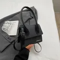 Minibolso bandolera de lona negra y cuero con logotipo de metal y asa superior - Negro