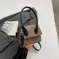 Bolso bandolera caqui minimalista con asas negras y detalle de logotipo metálico - Café