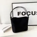 Borsa a secchiello minimalista in pelle scamosciata nera con eleganti nodi dorati - Nero Opaco