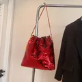 Vibrant red sequin bucket bag with gold chain strap and stylish drawstring detail - Red