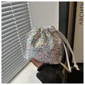 Detailed view of iridescent sequin drawstring bucket bag with shimmering light effect - White