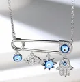 Macro detail of silver safety pin necklace with Hamsa hand and blue evil eye charms - Silver