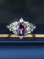 Detailopname van ovale paarse edelsteen ring met witte diamanten op blauw fluweel - US 6 / Zilveraars