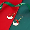 Macro detail of Christmas moon earrings with red Santa hat and green star accents - Crescent Moon Santa Hat