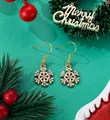 Close-up of golden snowflake earrings with sparkling rhinestones on Christmas background - Rhinestone Snowflake