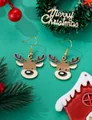 Close-up of cute Christmas reindeer enamel drop earrings on a green festive background - Q-version Reindeer