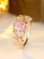 Macro shot of oval pink gemstone ring with floral leaf pattern and white zircon pavé - US 6 / Champagne Gold Pink Stone