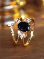 Macro detail van gouden stapelbare ringen met ovale blauwe zandsteen en witte zirkonia's - US 6 / Champagnegoud Blauwe Zandsteen