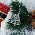 Close-up of hollow Christmas tree necklace with green stones and festive pine background - Silver Green Zircon Christmas Tree