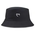 Classic black cotton bucket hat featuring a white heart print for sun protection - One Size / Black