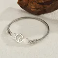 Silver twisted wire stainless steel bangle featuring a cutout Tree of Life charm - Silver