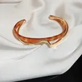 Détail d'un bracelet manchette doré ondulé avec résine ambre sur tissu de soie blanche - 1# Style Double Couche Ouvert Café Épissé Or
