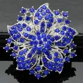 Macro-detail van zilveren bloembroche met meerlagige donkerblauwe fonkelende steentjes - Saffierblauw