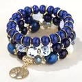 Dettaglio di bracciale bohémien multistrato con ciondolo albero della vita e accenti dorati - Stile Ciondolo Albero della Vita / Blu
