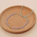 Detail of bohemian purple beads bracelet with adjustable blue cord and green stone charm - Light Blue Rope/Pale Green Round Bead/Lavender Gold Bead(BR0131)