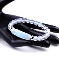 Blue moonstone beaded bracelet with silver metal spacers on a black hand model - Artificial Opal Bracelet (SL245A07)