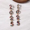 Detalle macro de pendientes 2025 con cristales de colores sobre aleación dorada - Estilo de Número 2025 / Multicolor