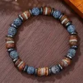 Détail d'un bracelet ethnique en perles de pierre bleue et oeil de tigre sur bois - Style Multi-matériaux Craquelé Bleu Et Perles Tambour Marron (ZJ14678)