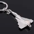 Sleek silver metal fighter jet keychain with polished finish on a reflective black surface - Silver