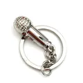 Portachiavi a forma di microfono in metallo argento lucido con trama a griglia su sfondo bianco - Stile Microfono Argento
