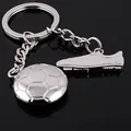 Polished silver metal keychain featuring football and soccer cleat pendants on black - Football and Soccer Cleat Style (GX-155)