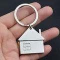 Polished silver house-shaped metal keychain being held to demonstrate scale and glossy finish - Silver